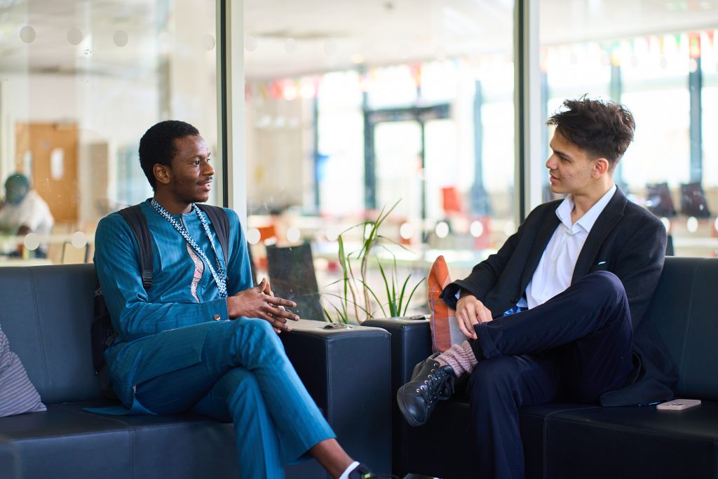 two young men sit chatting